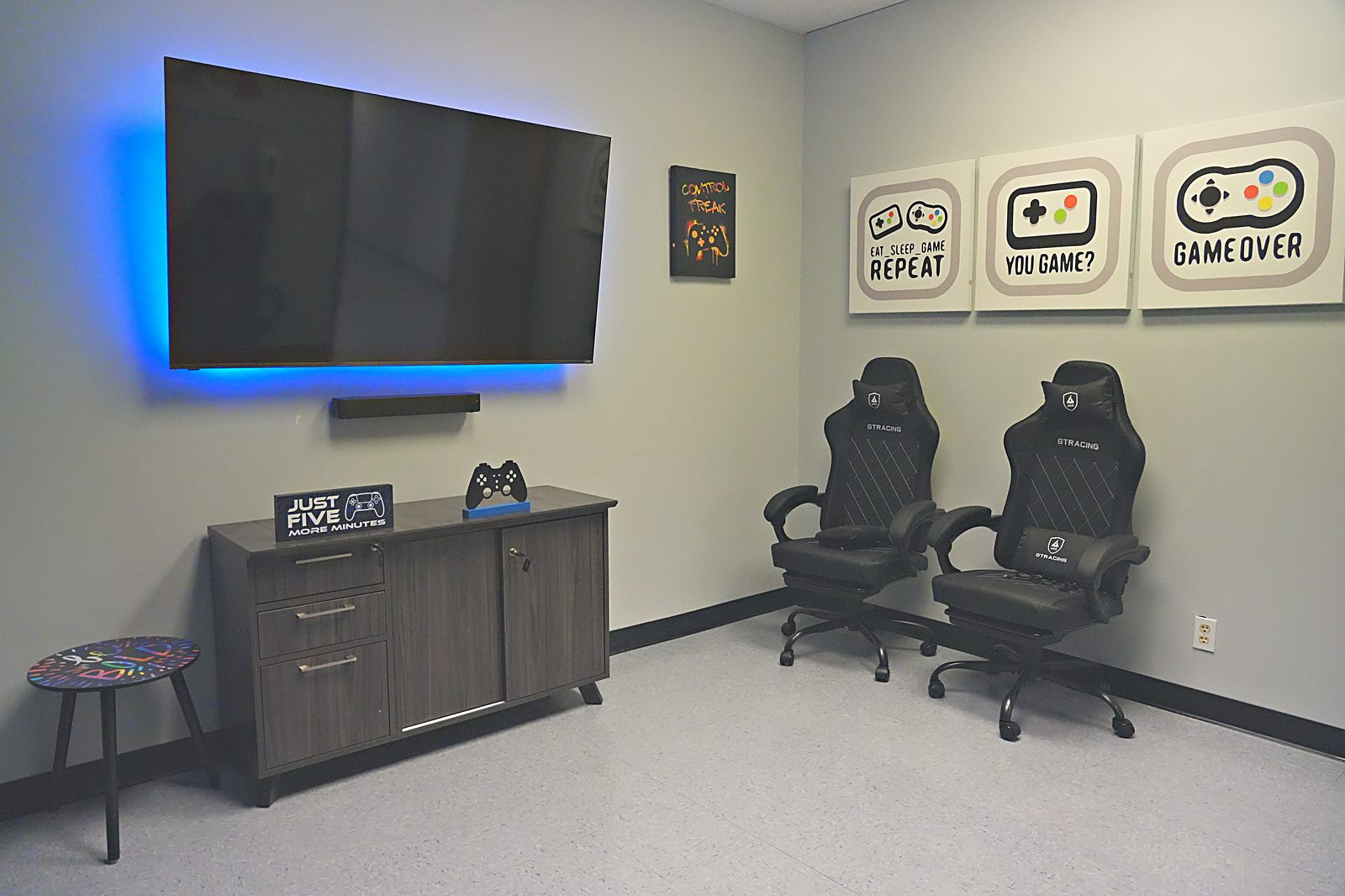 Teen gaming room with wall-mounted screen and gaming chairs