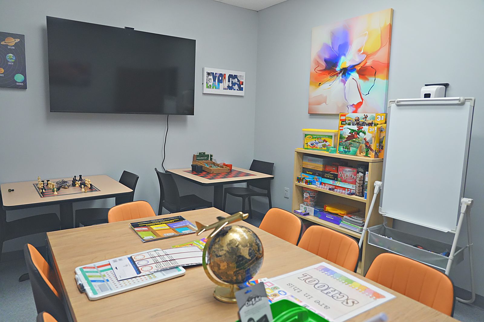 Learning room with tables, globes, and orange chairs