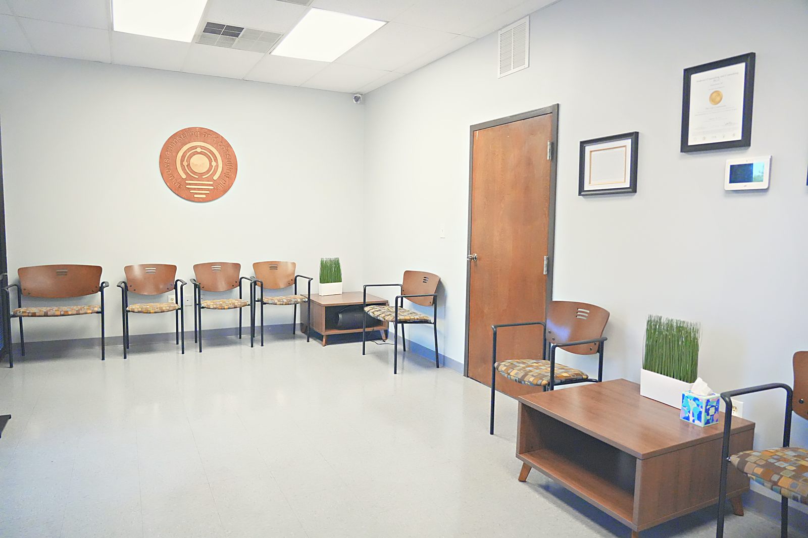 Waiting room with warm wood chairs and greenery